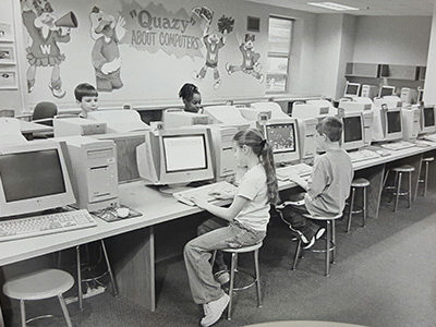 black and white image of students sitting in front of computers
